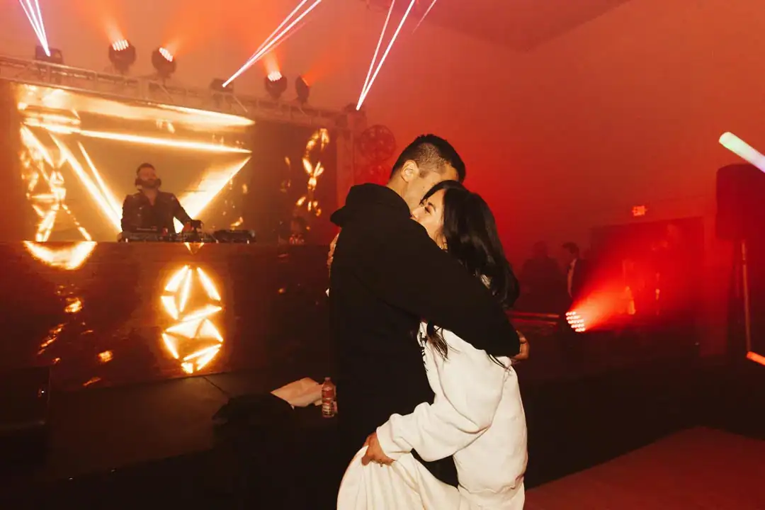 Christina and Steven embracing near the DJ stage at Grand Gimeno, Orange