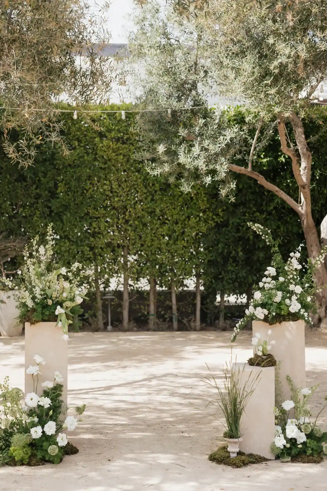 White floral columns framing the Olive Grove ceremony at Grand Gimeno, Orange
