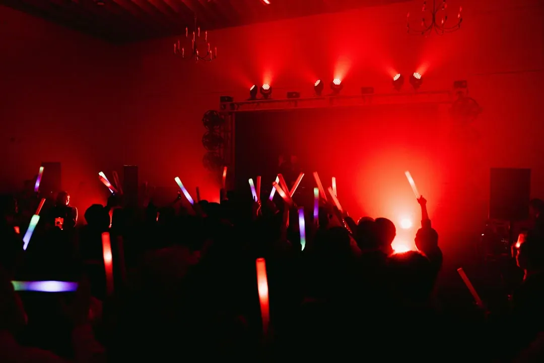 Guests dancing in the Grand Central hall at Grand Gimeno under red lighting, Orange
