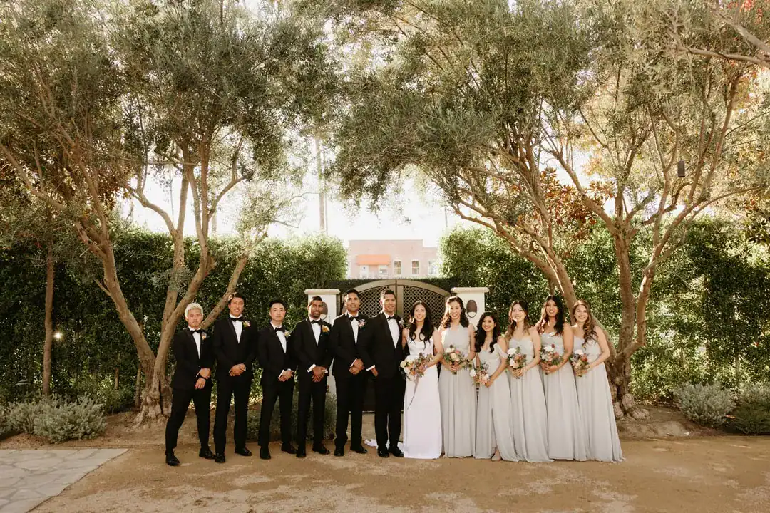 Christina and Steven with their wedding party under the olive trees at Grand Gimeno, Orange