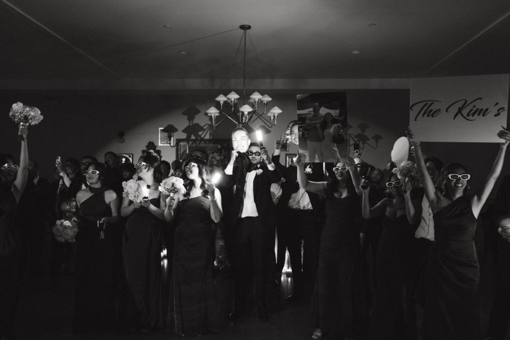 Black-and-white crowd under chandelier, Abbey & Edward wedding at The Harper, Costa Mesa
