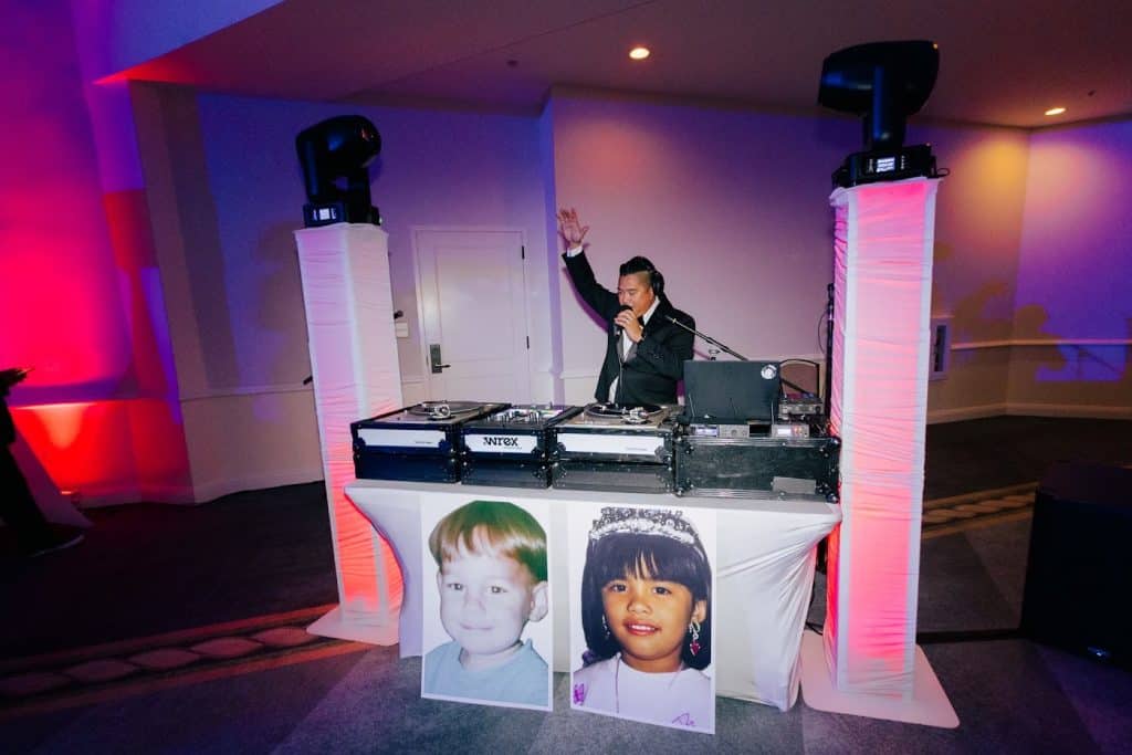 Booth wide, purple uplight, DJ Wrex hands up, Julia & Tim wedding at Hotel del Coronado