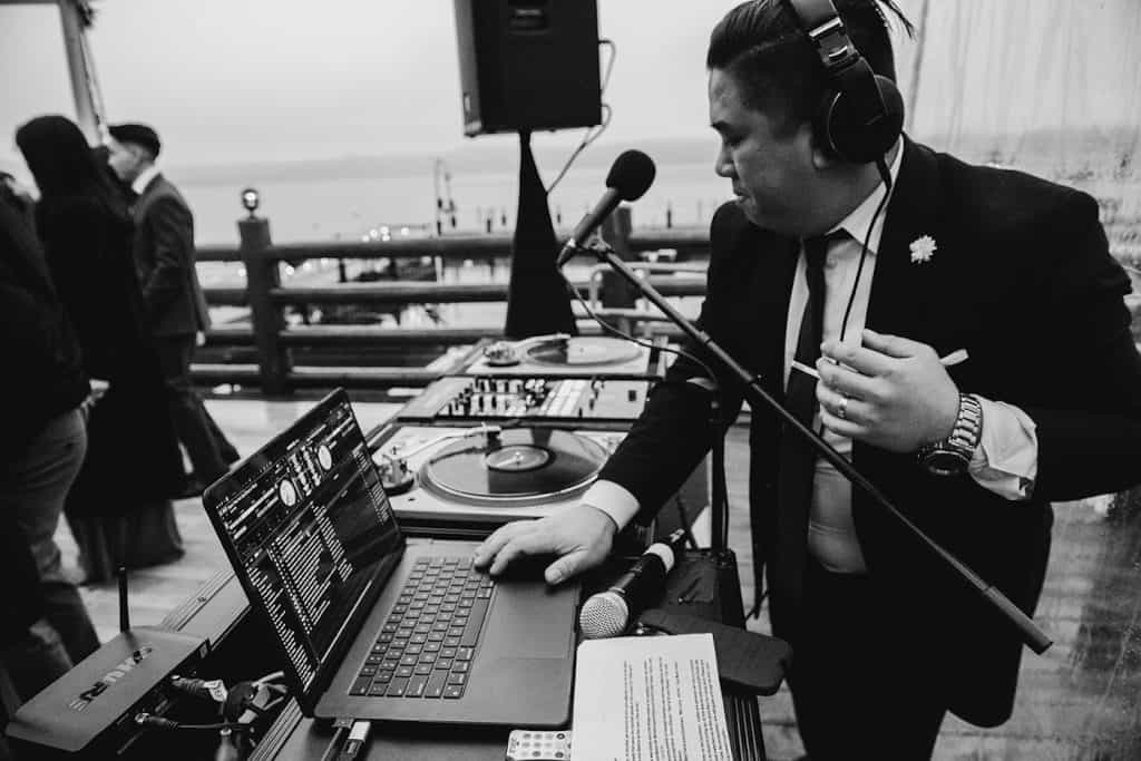 DJ Wrex at laptop and decks, lake behind, David & Marissa wedding at Sunnyside, Lake Tahoe