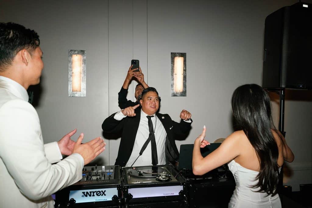 DJ Wrex at booth with couple celebrating in front, Lindsay & Sean wedding at The Maybourne Beverly Hills