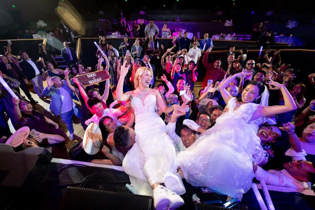 Packed floor, couple lifted and center, Mariah & Nikki wedding at The Wiltern